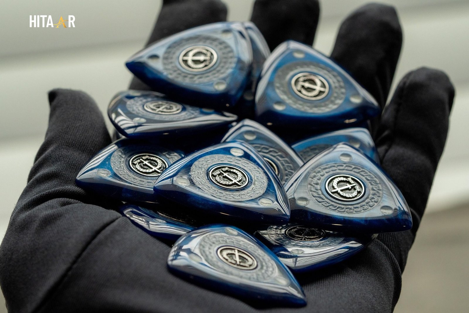 Different guitar plectrum thicknesses displayed on a wooden table.