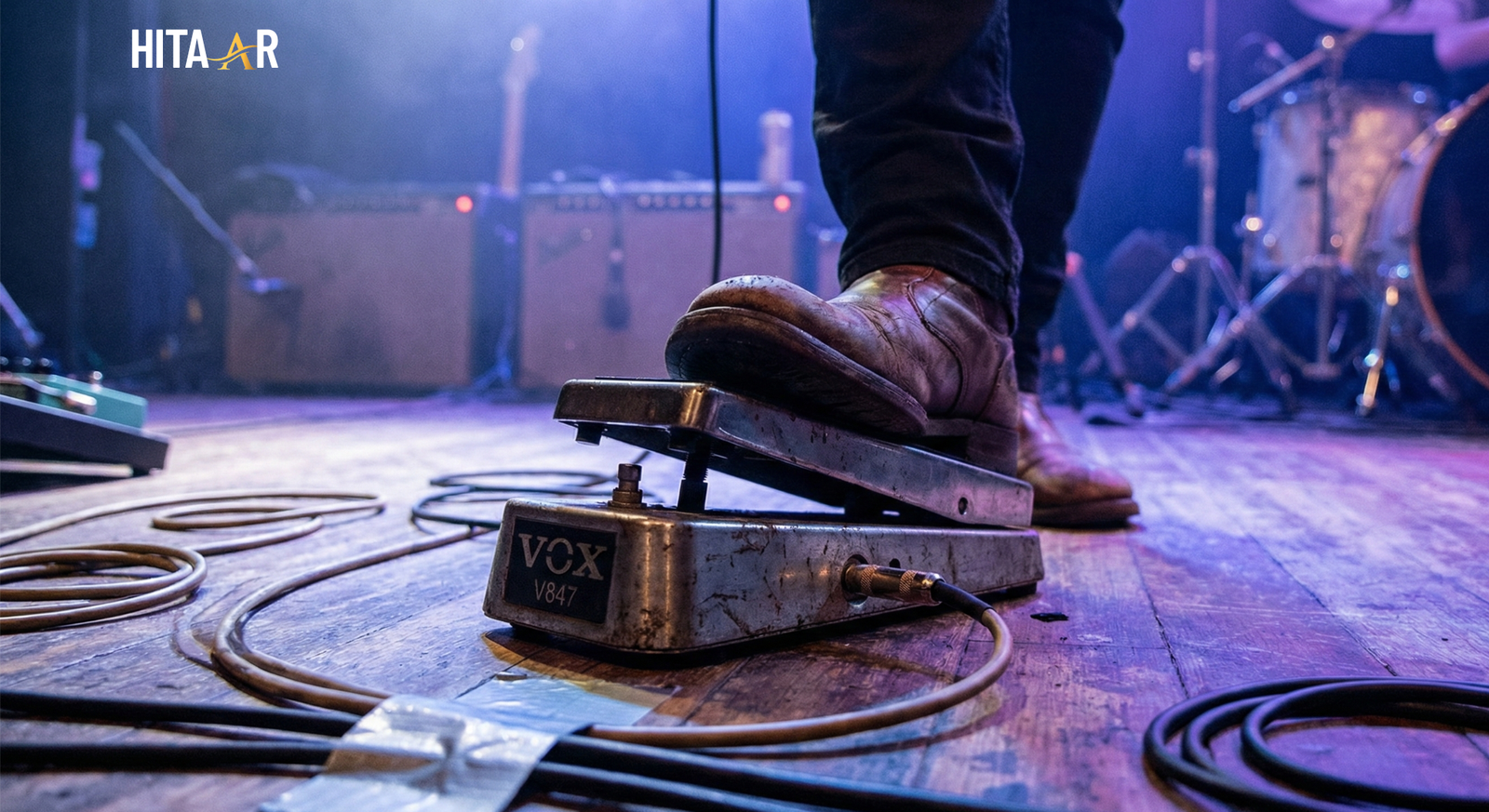 Wah wah guitar effects pedal on a stage floor with foot rocking for tone control.